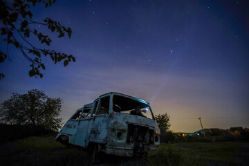 Fototapeta na wymiar night under the stars, abandoned car, rotten van