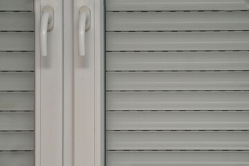 window blinds and close-up, double-leaf white plastic window, two window handles close-up, office window, protection of the room from sunlight, protective blinds, protection of the house from burglary