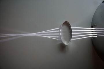 Fototapeta Parallel light passes through a convex lens and is refracted into the focus. Optics physics. obraz