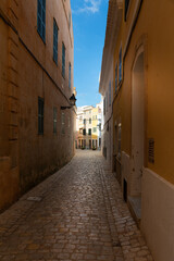 Calle estrecha del centro histórico de Ciutadella (Ciudadela) en Menorca. Callejón adoquinado del centro de la ciudad.