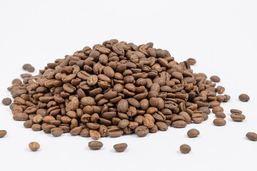 A pile of coffee beans on a white background, place for advertising.