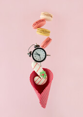 2023. Minimal abstract decorative Xmas card with dark red cone, alarm clock and colorful macaron...