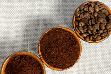 coffee beans, ground coffee in cups on a linen background