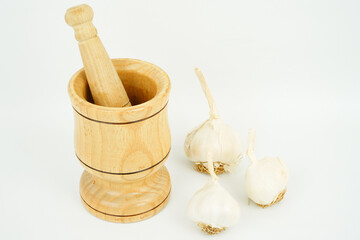 garlic and garlic masher in front of white background
