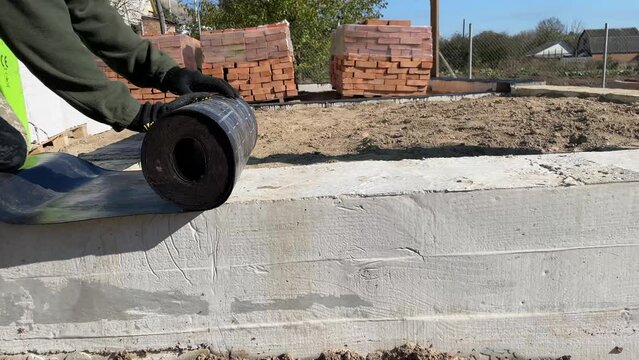Construction work on waterproofing the foundation. Roll waterproofing