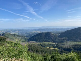 Naklejka premium Summer day blue sky mountains landscape. Nature landscape with sun and blue sky. Summer travel in Europe mountains. Nature, lake, forest, trees hiking path. Clouds on blue sky. Forest landscape hiking