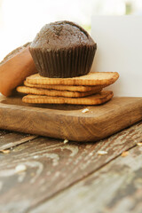Chocolate muffin with other pastries on wooden backdrop