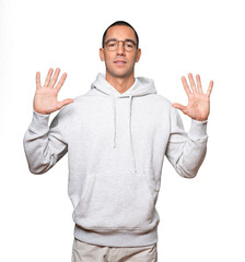 Young man making a number ten gesture