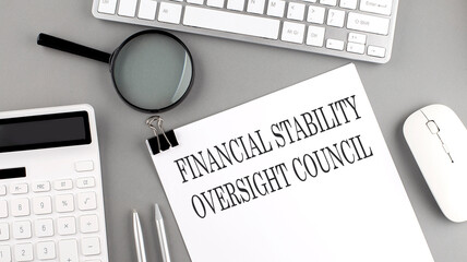 FINANCIAL STABILITY OVERSIGHT COUNCIL written on paper with office tools and keyboard on the grey...