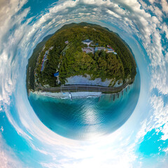 Fototapeta premium above the beach with stone breakwaters near the hotel buildings in the resort village near the Black Sea - aerial view on a sunny summer day