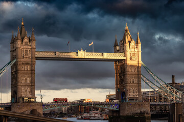 Fototapeta na wymiar Historic Bridge over River Thames and Cityscape Skyline during dramatic sunset. Tower Bridge in City of London, United Kingdom. Travel Destination.
