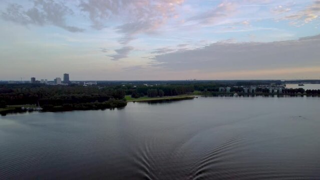 Drone footage of the Netherlands amaizing clouds with sunset and a boat in the lake.