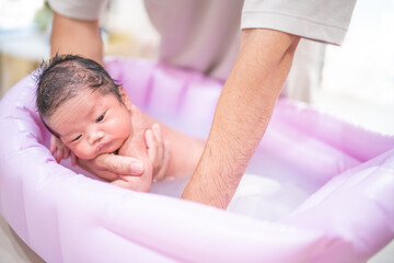Fototapeta na wymiar 沐浴中うつぶせで洗われる赤ちゃん（新生児・パパ・父・子供・子ども・0歳・育児・子育て・お風呂・入浴）