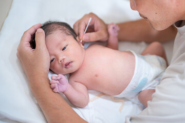 沐浴後耳を掃除される赤ちゃん（新生児 パパ 父 子供 子ども 0歳 育児 子育て お風呂 入浴）