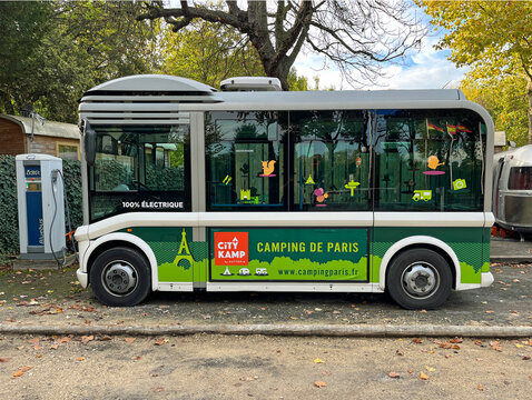 Paris, France - October 20, 2022: Camping Paris electric shuttle bus being charged. Nobody in de vehicle.