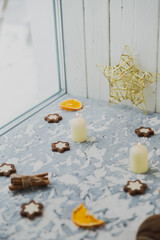 Christmas still life on the windowsill. Concrete background, gifts, candles and garlands