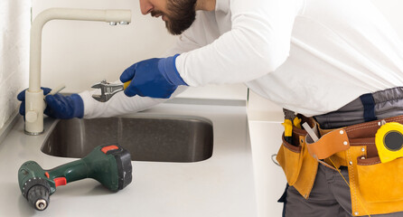 Male Plumber In Overall Fixing Sink