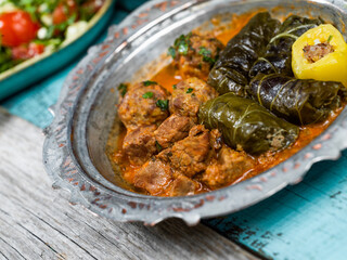 Eid Mubarak Traditional Ramadan Iftar dinner. Assorted tasty food in authentic rustic dishes on wooden blue background. Turkish Bosnian food meat kebab, pita, Sarma, klepe, sogan dolma.