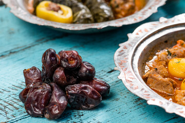 Eid Mubarak Traditional Ramadan Iftar dinner. Assorted tasty food in authentic rustic dishes on wooden blue background. Turkish Bosnian food meat kebab, pita, Sarma, klepe, sogan dolma.