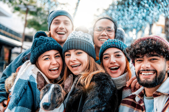Multiracial smiling friends taking selfie shot smiling at camera - Laughing young people walk outdoor with a dog and having fun on the city - Concept of community, youth lifestyle and friendship.
