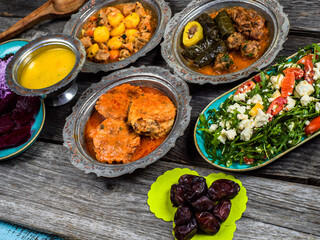 Eid Mubarak Traditional Ramadan Iftar dinner. Assorted tasty food in authentic rustic dishes on wooden blue background. Turkish Bosnian food meat kebab, pita, Sarma, klepe, sogan dolma.