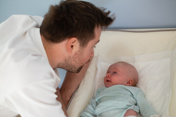 Young father and newborn baby girl spending time together