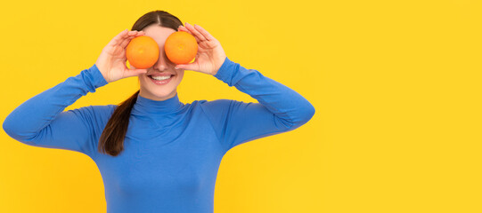 Woman isolated face portrait, banner with copy space. funny young woman holding orange citrus fruit on yellow background, vitamin.