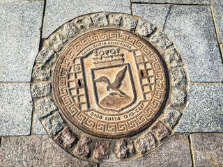 Decorative manhole cover with coat of arms in Sopot, Poland, Europe
