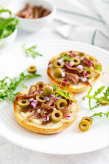 Anchovy toasts with olives and arugula