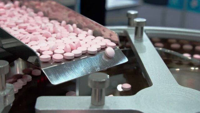 Closeup of pharmaceutical medicine tablet pill production, pharmacy medicine capsule pill in production line at medical factory. 