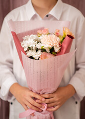 A bouquet of flowers in the hands of a girl. Floristics.