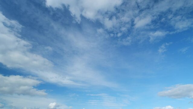 Blue sky with cumulus and cirrus on different layers clouds. Beautiful sky with clouds background. Timelapse.