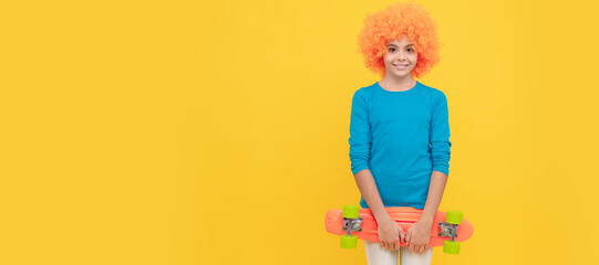 cheerful selfish child girl in curly wig hold penny board, copy space, childhood. Funny teenager child on party, poster banner header with copy space.