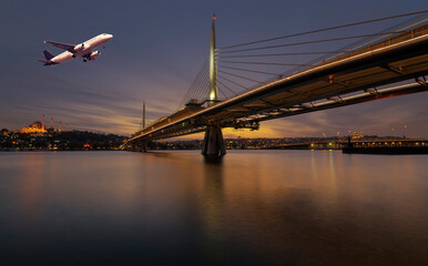 Istanbul metro bridge with evening lights an airplane on sky
