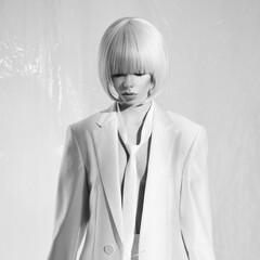 Studio fashion photo of young elegant woman in white men's jacke - 540330562