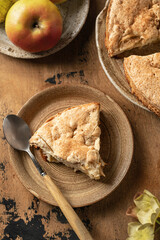Piece of apple pie charlotte with apples and flowers on wooden background, top view, flat lay
