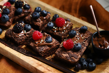 Macro. Brownie cakes with berries and chocolate on top. Delicious chocolate dessert.