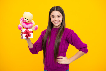 Portrait of teenager child girl 12, 13, 14, years old holding Christmas gift box. Teen giving...