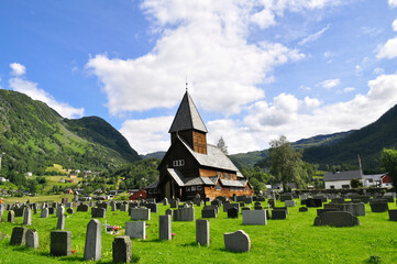 Fototapeta na wymiar Stavkirke Roldal, Hordaland, Norway - old wooden church with cemetery and stone graves