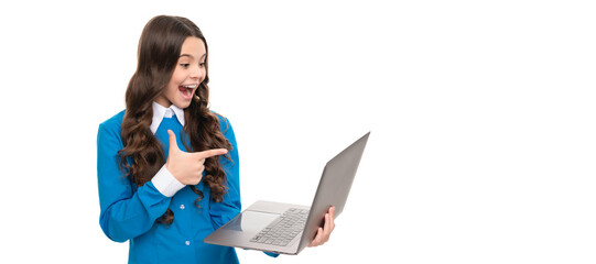 surprised child long curly hair pointing finger on laptop isolated on white, school blog. School girl portrait with laptop, horizontal poster. Banner header with copy space.