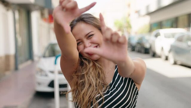 Young beautiful hispanic woman smiling confident doing photo gesture with hands at street