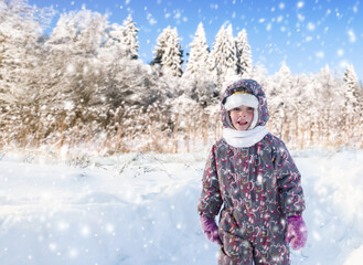Fototapeta na wymiar a child walks in a snowy forest during a snowfall.