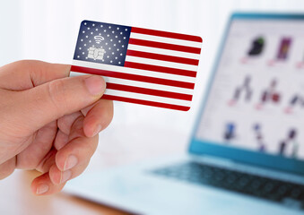 Hands holding plastic credit card and using laptop. Online shopping concept in United States