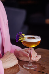 girl holding a glass with a cocktail in a cafe or restaurant: close-up, restaurant concept