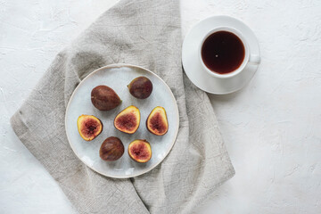 Still life with coffee cup and figs on white textured table. Top view, flat lay