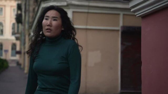 4k Two young women are walking along city street and showing confusion emotions spbd. Close view of caucasian, asian female walk through old town and show sadness or fear for camera, pose on
