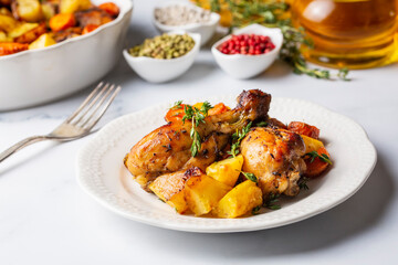 Baked chicken thighs and fried potatoes look delicious.