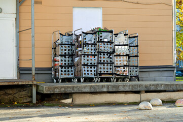 pallet and trash in plastic garbage bags and paper boxes near a building wall on a city street.