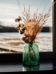 dry flowers in a vase on the window