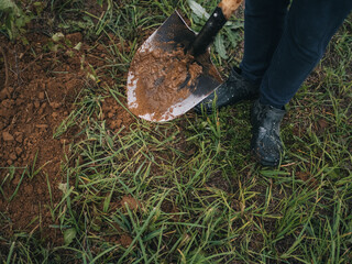 girl with a dirty shovel in the garden